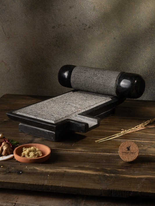 Traditional Handmade silbatta placed on table surrounded by fresh ingredients.