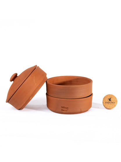 Three tier terracotta sprout maker with lid placed on a plain white background highlighting its natural clay finish and tableware purpose.